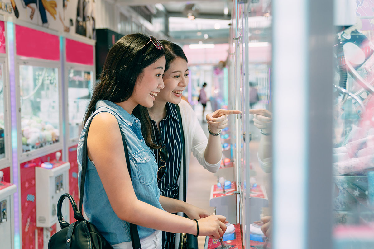 Girls playing at the claw machine arcade.